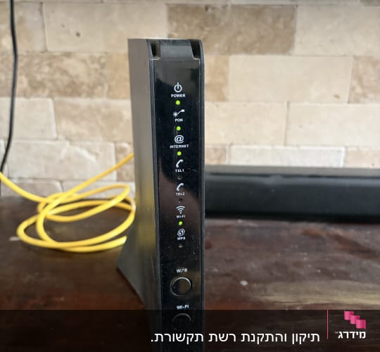 נתב אינטרנט עם כבלים צהובים על שולחן עץ